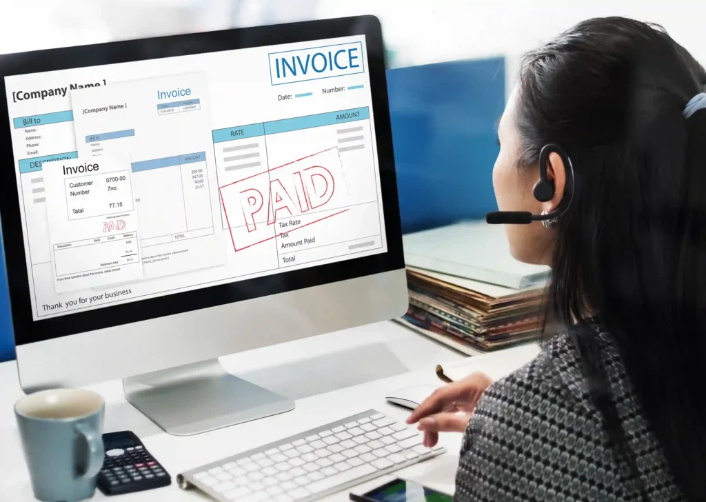 Expert medical billing specialist in a modern office reviewing a paid medical invoice on his computer screen, demonstrating successful HIPAA-compliant RCM services that increase cash flow for US healthcare providers.